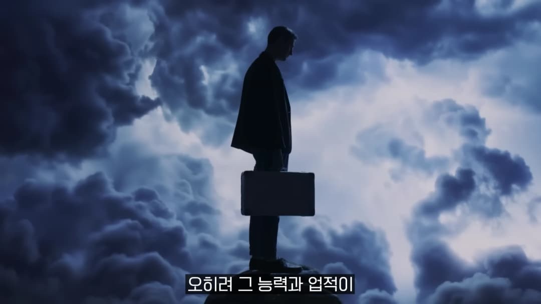 어두운 구름을 배경으로 서류 가방을 들고 절벽 끝에 서 있는 남성의 실루엣