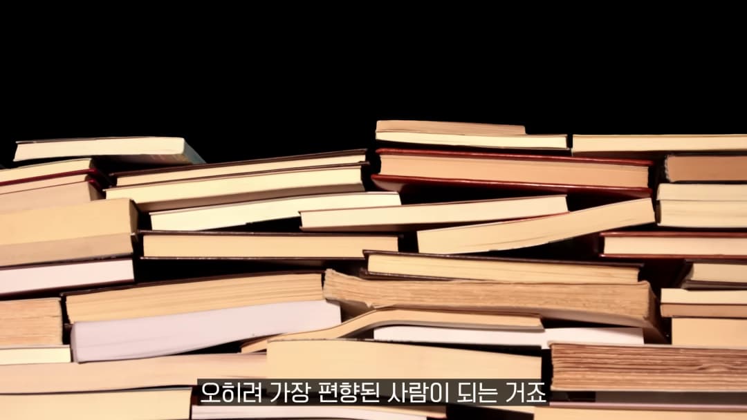 검은 배경 앞에 쌓여 있는 여러 권의 낡은 책들