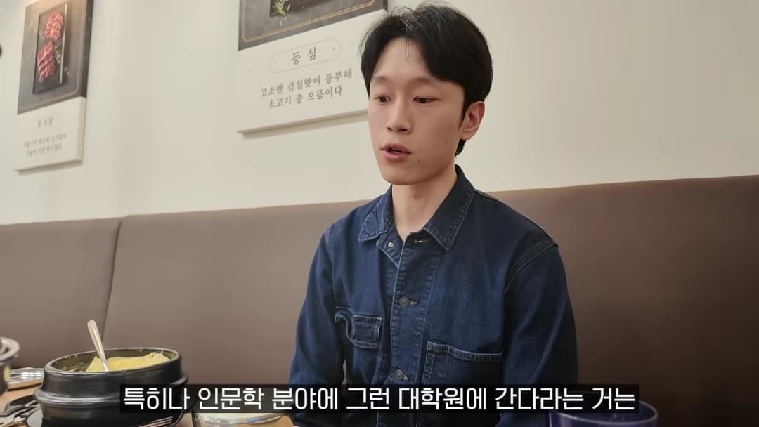 식당에 앉아 진지한 표정으로 이야기를 나누는 남성