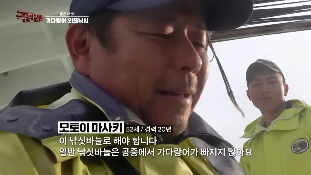 배 위에서 형광색 작업복을 입은 어부 두 명이 인터뷰를 하고 있는 모습