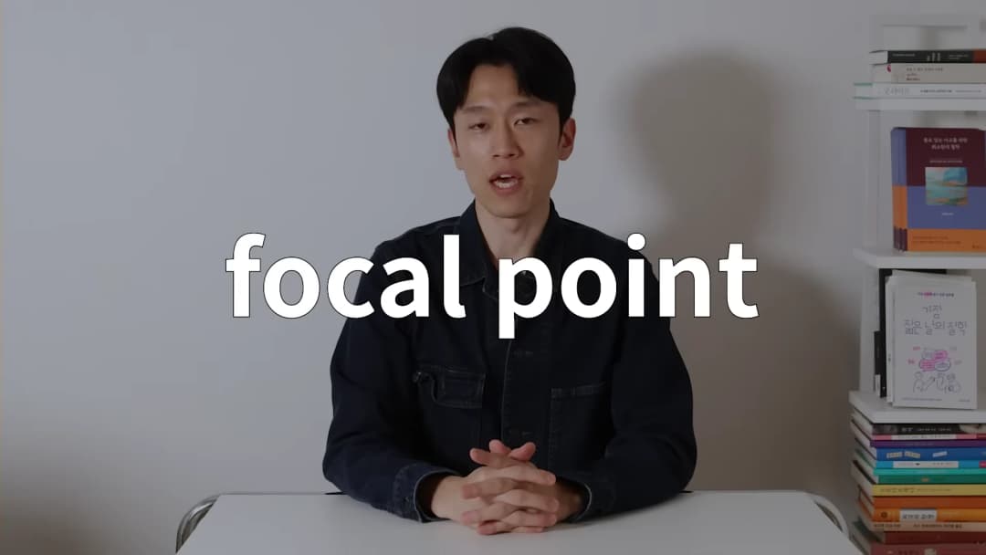 흰 벽을 배경으로 책장이 놓인 방에서 남성이 앉아 이야기하고 있으며, 화면 중앙에 'focal point'라는 글자가 크게 적혀 있습니다.